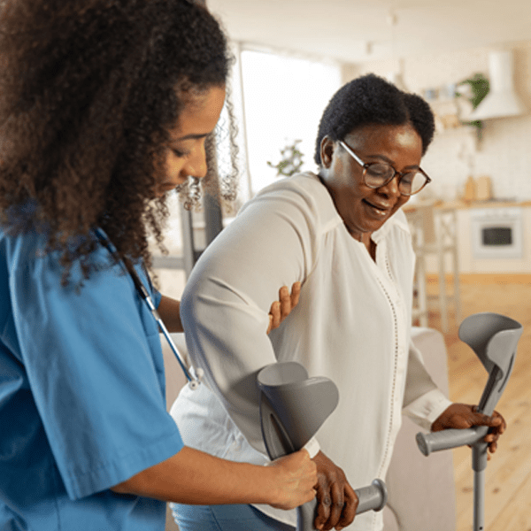 Nurse helping woman to stand up