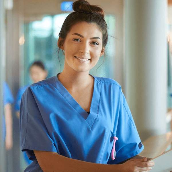 Female nurse holding a file poses for the camera